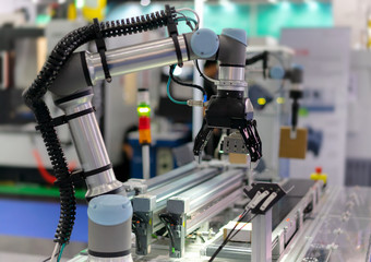 Factory 4.0 concept : View of Gripper on universal robot is sorting goods on automatic conveyor by...