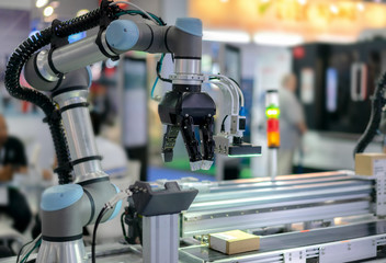Factory 4.0 concept : View of Gripper on universal robot is sorting goods on automatic conveyor by...