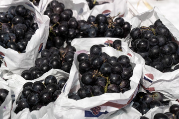 Fresh black grapes on paper bag
