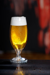 Glass of beer on the dark background