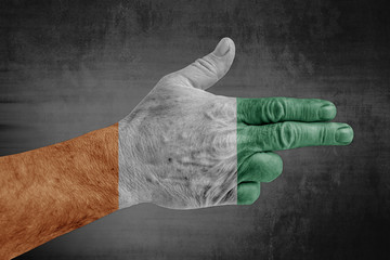 Cote d'lvoire flag painted on male hand like a gun