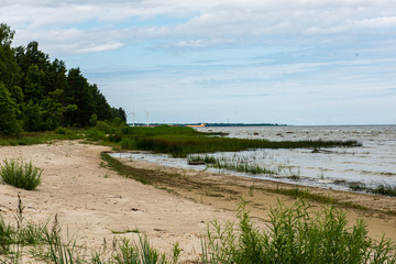 empty sea beach in summer with waves and broken clouds