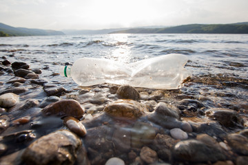 Plastic bottle waste on rivershore , water pollution concept