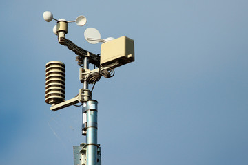 Weather station instruments against blue sky background