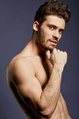 Fototapeta premium Thoughtful handsome athlete making serious decision, macho with a hand on his chin making up idea. close up photo. studio shot