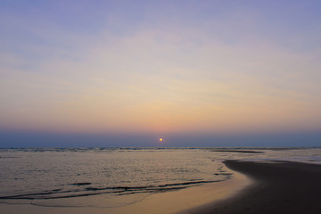 Fototapeta premium Beautiful sky colorful sunset on the ocean, natural landscapes. Deserted beach, the sun sets in the clouds above the sea.