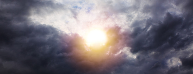Beautiful sunset sky above gray clouds with dramatic light.