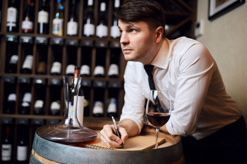 pensive thoughtful man with a pen is his hand looking up. barmen working in fine restaurant. close up photo