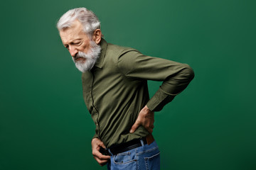 old man suffering from referred pain in the back. weakness concept. shooting, piercing pain in...