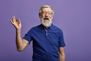 happy positive handsome old man shows Ok sign, no problems, health is ok.everything is ok. close up portrait. isolated blue background. happiness, success concept - 269213030
