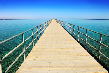 Obraz premium Panoramic image of a wooden bridge in the sea. 