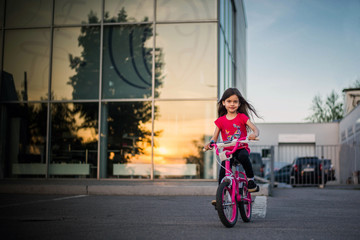 beautiful girl riding her bike on sunset background