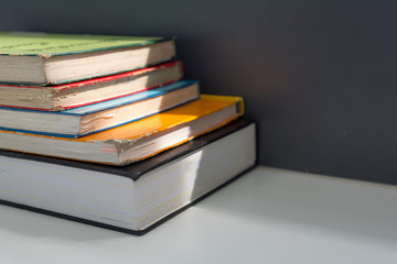 Close up books stacked on the table at the university library in selective focus.