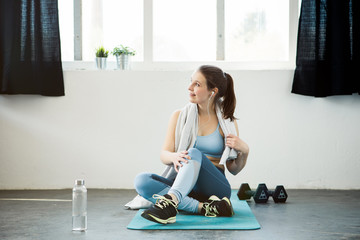 Young woman taking a break from workout in urban loft environment