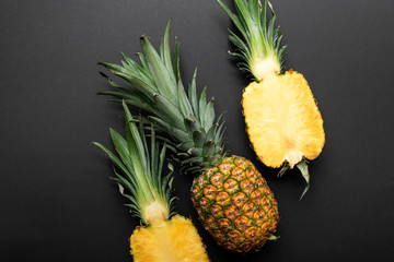 top view of ripe yellow pineapples on black background