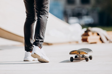 The man rides skateboard on a platform outside next to the house at the sunny warm day