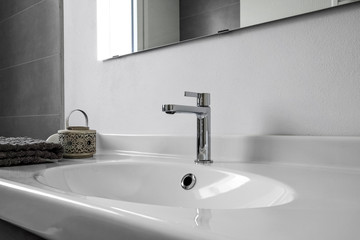 interior shot of a modern bathroom in the foreground the washbasin with a steel tap