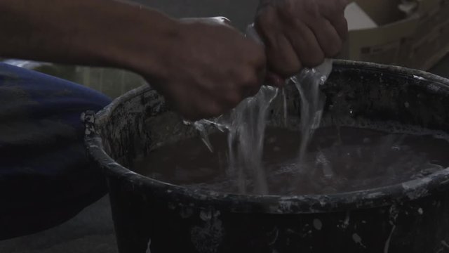 hands squeeze a rag