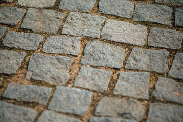 Brown square cobblestone pavement.Top view on the stone road close up.Layout or vintage grunge texture.