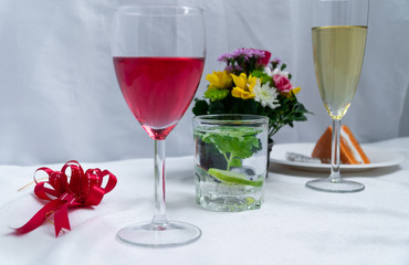 Set of drinks and desserts on table covered by white cloth.
