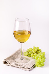 Glass of White Wine and Branch of Green Grapes on White Background