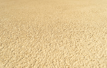 Grainy yellow concrete wall texture, at an angle