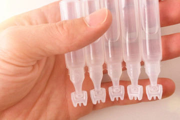 Hand with pipettes eye drops close up