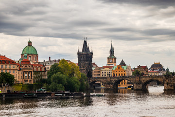 Fototapeta premium Tourist boats on Vltava river in Prague with Charles bridge and historic buildings in the background