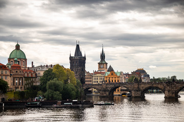 Tourist boats on Vltava river in Prague with Charles bridge and historic buildings in the background