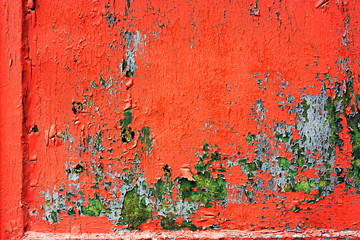 Old colored cracked wall. Grunge red and green wall texture for design. Old paint texture is chipping and cracked fall destruction. Abstract background of old red painted wall.