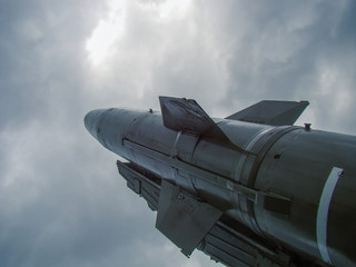 A military missile is ready for launch on a background of a threatening sky. Stabilizers. The concept of war, conflict, threats. 