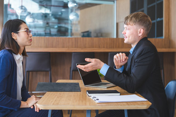 Human resources manager conducting job interview with young female candidate in office.