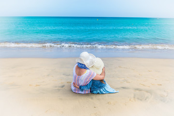  mother and daughter relax on the beach and admire the seaside view