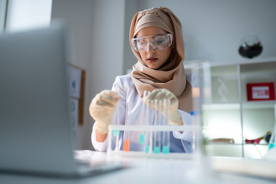 Young chemist wearing hijab working in laboratory