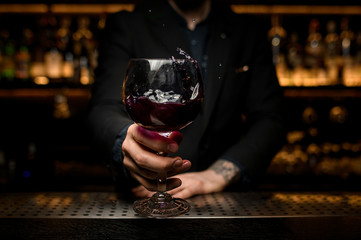 Close shot of splashing alcohol cocktail in glass