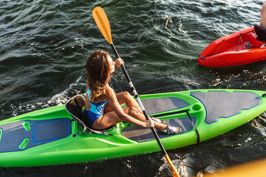 Healthy fit girl on a kayak in the ocean