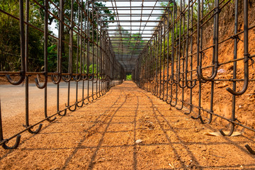 Low angle view of metal structure with grid pattern at a construction site along the country road in rural area.