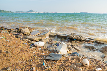 Fototapeta na wymiar Electronic waste and foam become garbage on the beaches and birty sea water near the pier is a problem and pollution in Chonburi, Thailand