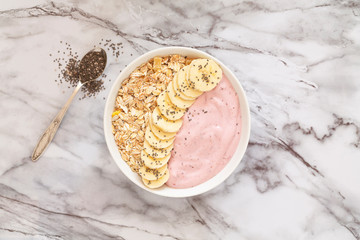 Healthy breakfast berry smoothie bowl topped with banana, muesli and chia seeds. Top view. Breakfast recipes