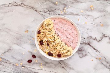 Healthy breakfast berry smoothie bowl topped with banana, muesli and chia seeds. Top view. Breakfast recipes