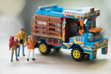 Miniature people : Traveler with backpack standing next to Thai farming trucks. Hitchhiking concept