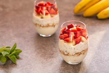 Homemade yogurt parfait with granola, strawberries, bananas and Chia seeds in glasses. Diet dessert with yogurt, Chia, muesli and fresh berries. Healthy breakfast 