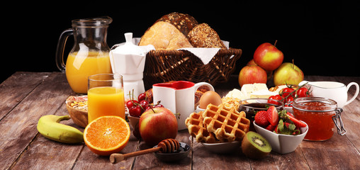 Breakfast served with coffee, orange juice, croissants and strawberry, jam and tea. breakfast table