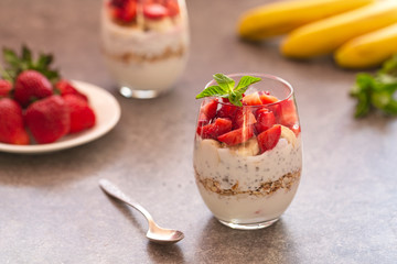 Homemade yogurt parfait with granola, strawberries, bananas and Chia seeds in glasses. Diet dessert with yogurt, Chia, muesli and fresh berries. Healthy breakfast 