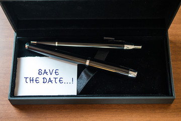 Writing note showing Save The Date. Business concept for Organizing events well make day special event organizers Close up case ball point fountain pens set blank card lying on wooden