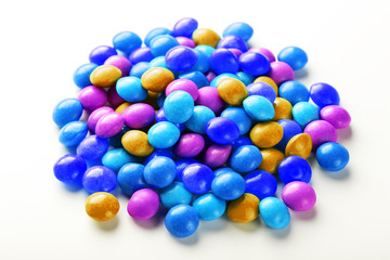A rainbow of color from multicolored candies close-up, multi-colored glaze dragee on a white background