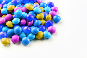 A rainbow of color from multicolored candies close-up, multi-colored glaze dragee on a white background