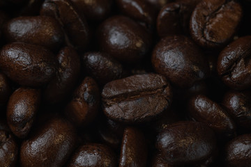 close up of pile roast coffee beans on wooden board