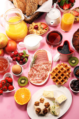 Huge healthy breakfast on table with coffee, orange juice, fruits, waffles and croissants. Good morning concept.