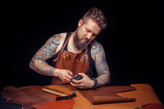 Professional Tanner works with leather goods at his workshop